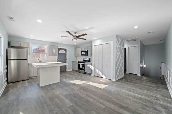 a view of a kitchen with refrigerator and wooden floor