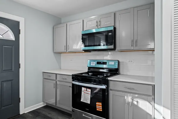 a kitchen with white cabinets and black appliances