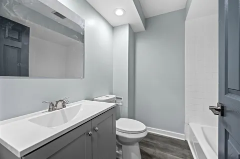 a bathroom with a sink toilet and a mirror