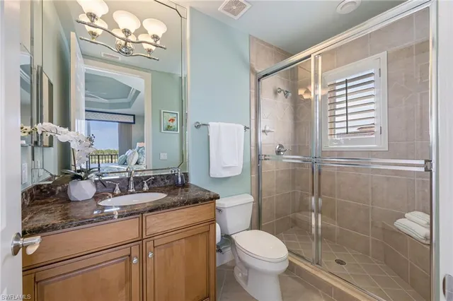 a bathroom with a granite countertop sink a toilet and a mirror
