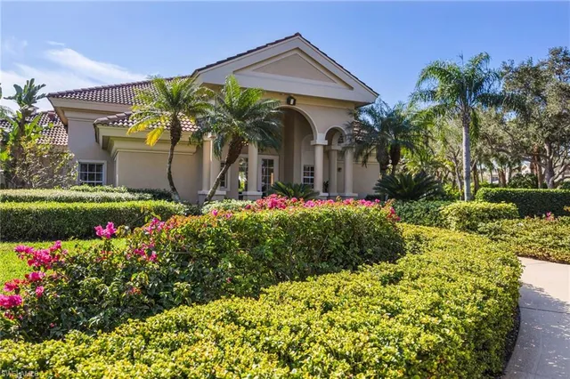 a front view of a house with a yard and fountain