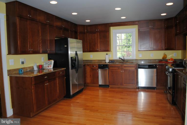 77 Forest Grove Road Amissville, VA 20106 - Photo 5 of 30 a kitchen with stainless steel appliances granite countertop wooden cabinets a refrigerator a sink a stove and a wooden floors