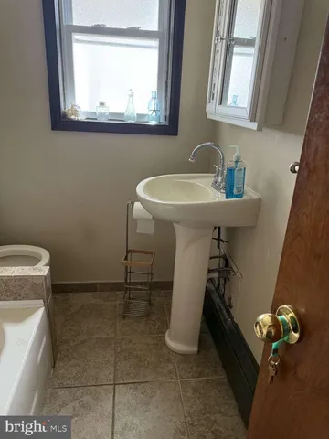 a bathroom with a sink a toilet and a mirror