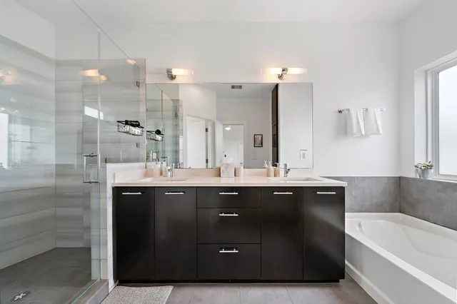 a spacious bathroom with a sink a bathtub a mirror and a shower