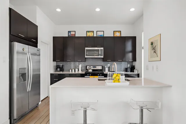 a view of living room with stainless steel appliances cabinets and a window