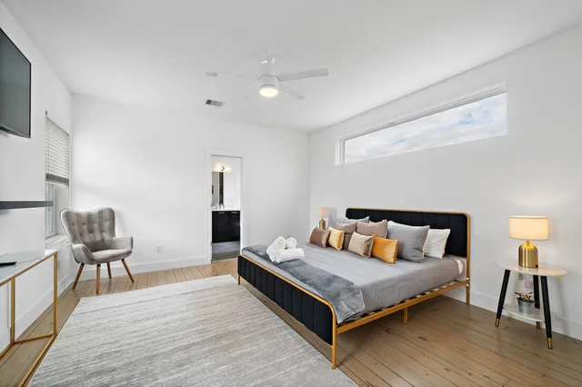 a bedroom with a bed and wooden floor