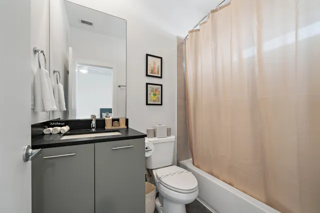 a bathroom with a granite countertop sink toilet and a mirror