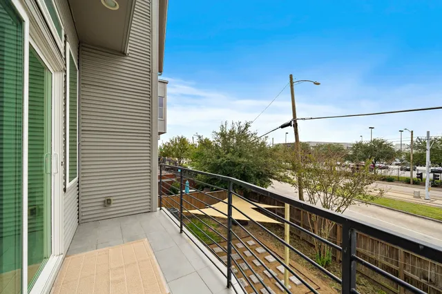 a view of a balcony with wooden floor and iron stairs