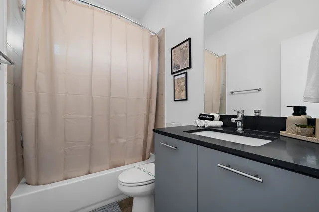a bathroom with a granite countertop sink toilet and shower