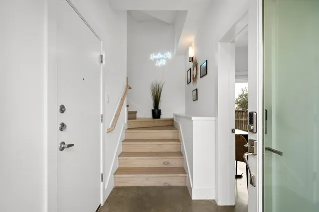 a view of staircase with white walls and a painting