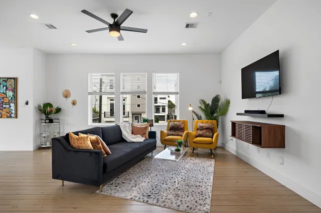a living room with furniture flat screen tv and wooden floor