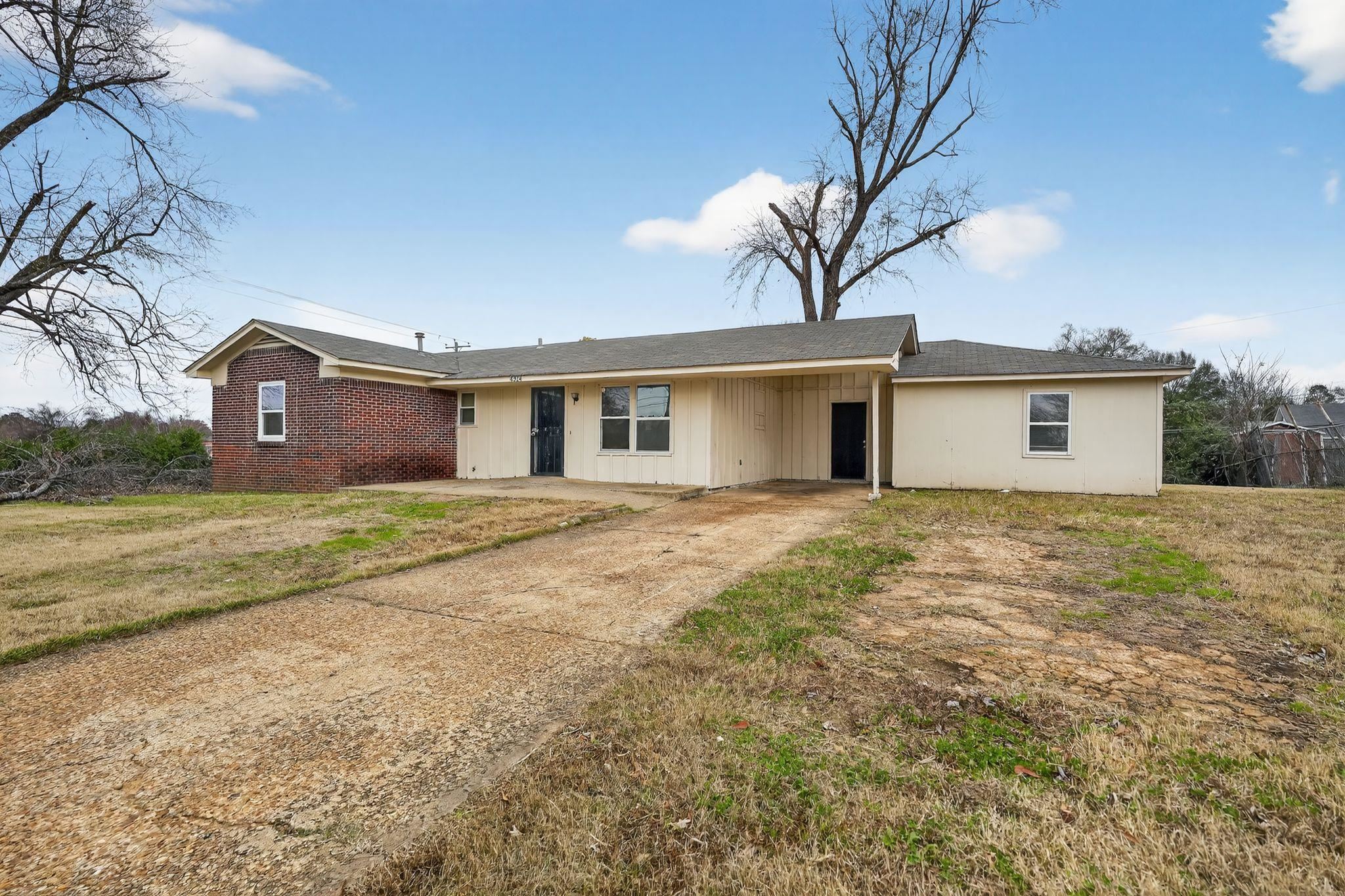 4314 Ford Road Memphis, TN 38109 - Photo 2 of 31 Ranch-style home with driveway, an attached carport, a front lawn, and a shingled roof