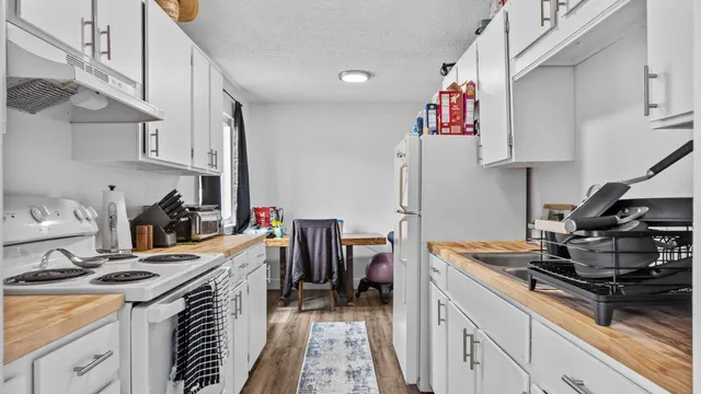 a kitchen with a stove and a wooden floor