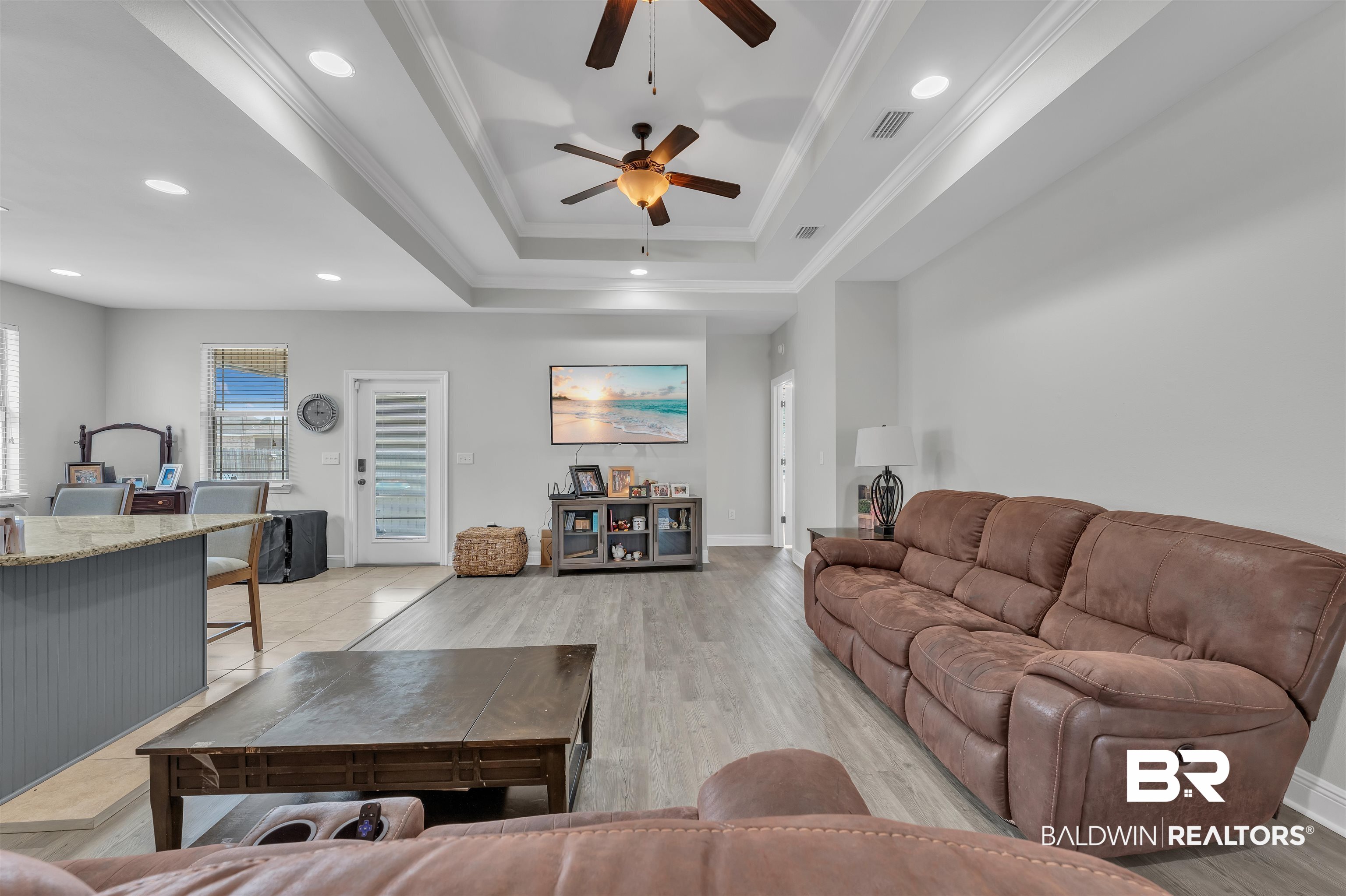 22565 Nana Loop East Silverhill, AL 36576 - Photo 4 of 26 Living area featuring a tray ceiling, ornamental molding, visible vents, and ceiling fan