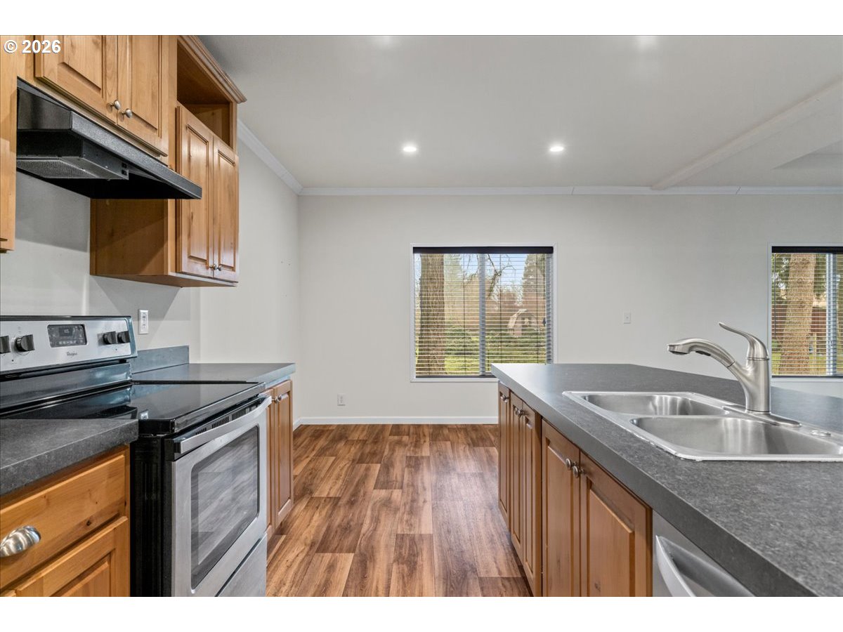 7136 South King Street Canby, OR 97013 - Photo 19 of 31 a kitchen that has a sink a stove and wooden floor