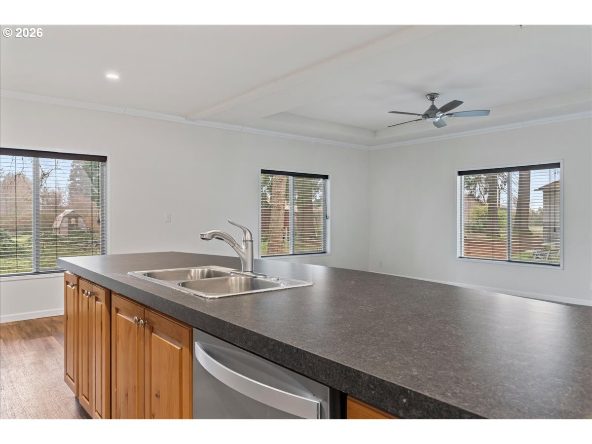7136 South King Street Canby, OR 97013 - Photo 20 of 31 a kitchen with a sink granite counter top a window and ceiling fan