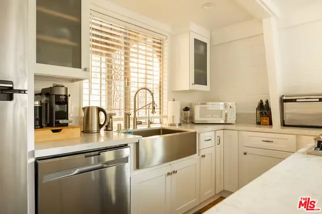 a kitchen with stainless steel appliances a refrigerator sink and stove