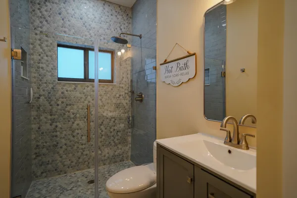 a bathroom with a sink a toilet and shower