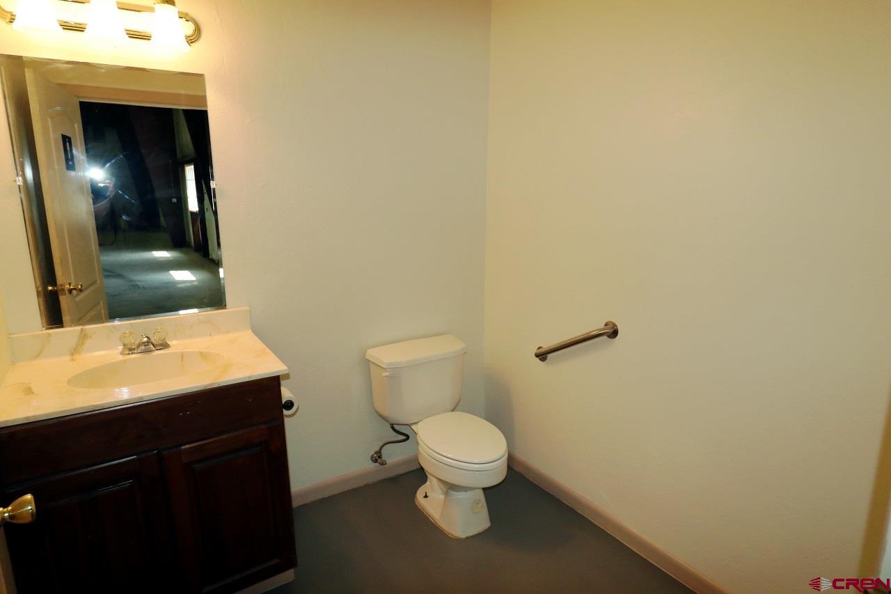 2011 Industrial Road Cortez, CO 81321 - Photo 11 of 16 a bathroom with a toilet a sink and mirror