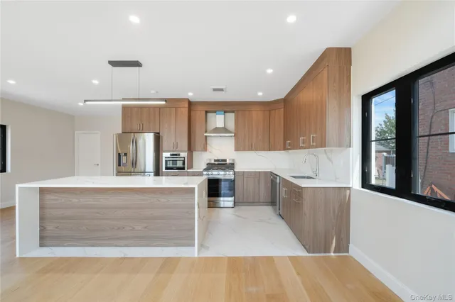 a large kitchen with kitchen island a sink stainless steel appliances and cabinets