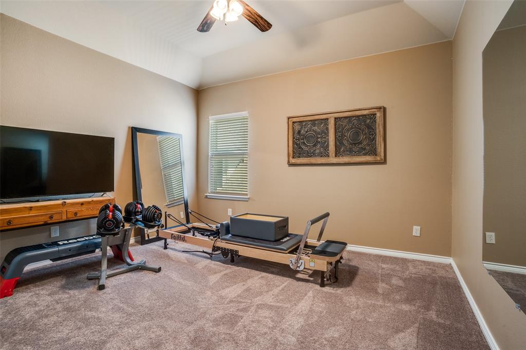 10109 Petrified Tree Lane McKinney, TX 75072 - Photo 18 of 27 a living room with furniture gym equipment and a flat screen tv