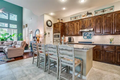 a kitchen with granite countertop a sink cabinets and stainless steel appliances