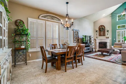 a dining room with furniture a chandelier and window