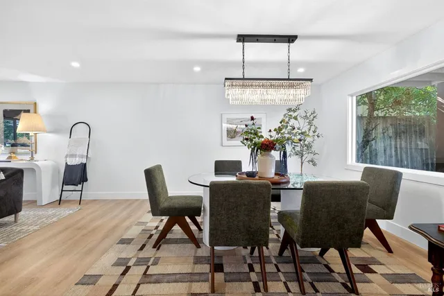 a kitchen with stainless steel appliances granite countertop a stove top oven a sink dishwasher and white cabinets with wooden floor