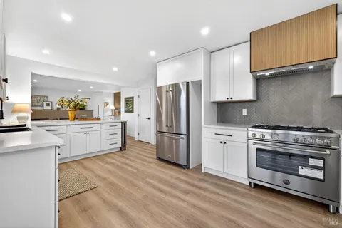 a kitchen with stainless steel appliances white cabinets and a refrigerator