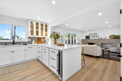 a kitchen with stainless steel appliances granite countertop a stove a sink dishwasher and a refrigerator with wooden floor