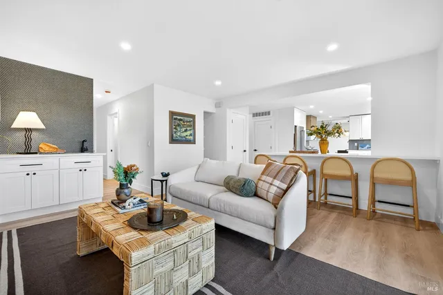 a view of a livingroom with kitchen and a window