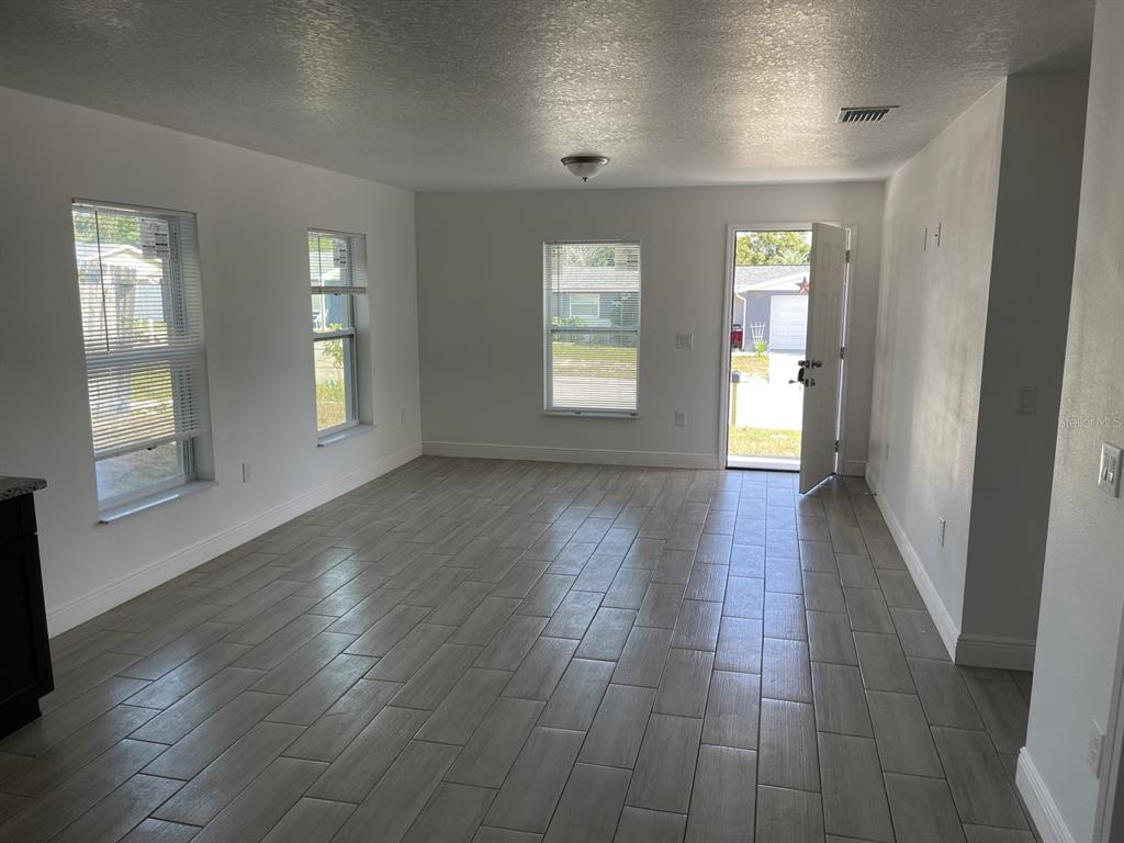9835 Gray Fox Lane Port Richey, FL 34668 - Photo 12 of 17 an empty room with wooden floor and windows