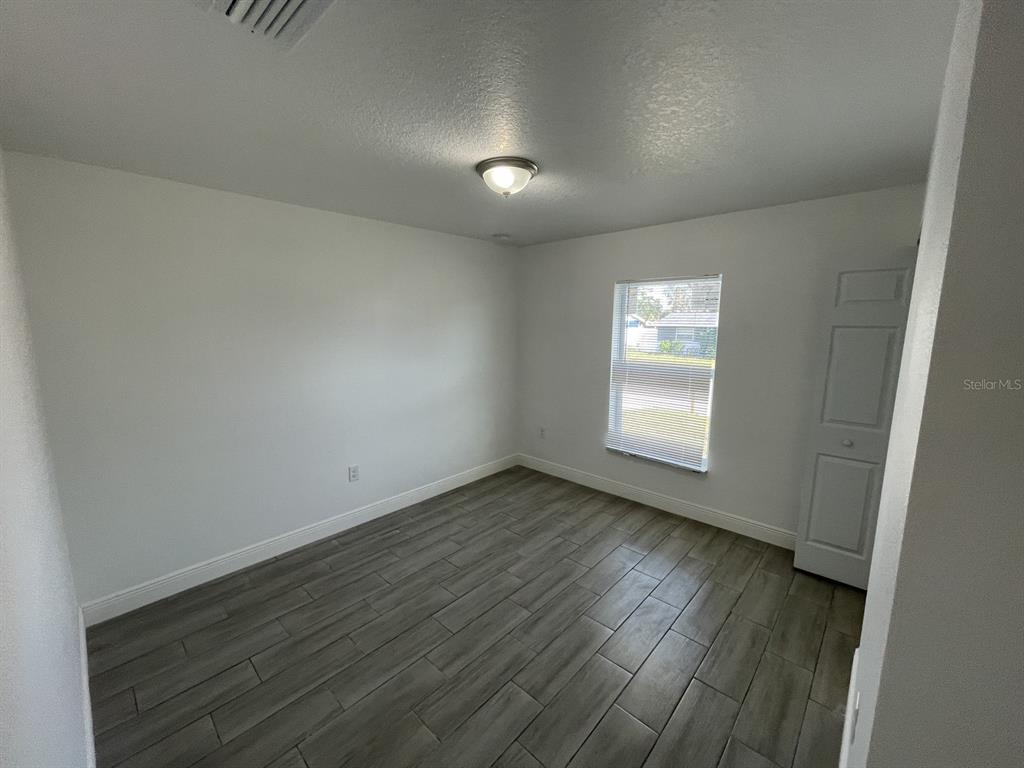 9835 Gray Fox Lane Port Richey, FL 34668 - Photo 14 of 17 an empty room with wooden floor and windows
