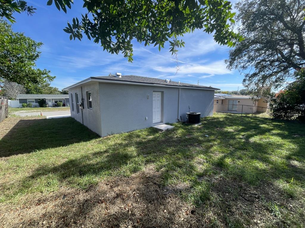 9835 Gray Fox Lane Port Richey, FL 34668 - Photo 9 of 17 a backyard of a house with plants and large tree