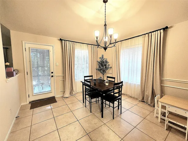 a view of a dining room with furniture and a chandelier