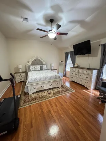 a bedroom with a bed and wooden floor