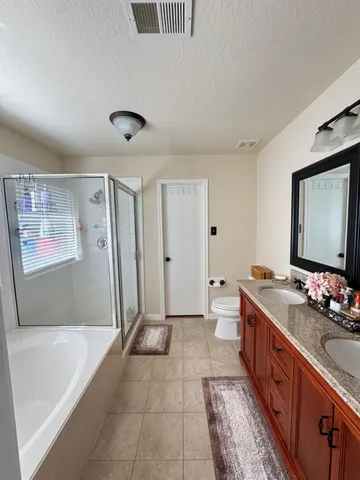 a spacious bathroom with a double vanity sink a mirror and a bathtub
