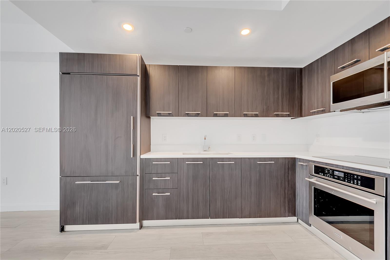 45 Southwest 9th Street, Unit 2105 Miami, FL 33130 - Photo 5 of 27 a kitchen with stainless steel appliances granite countertop a refrigerator and a stove top oven
