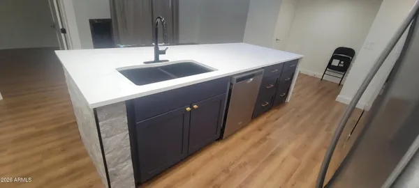 a kitchen with a sink and wooden floor