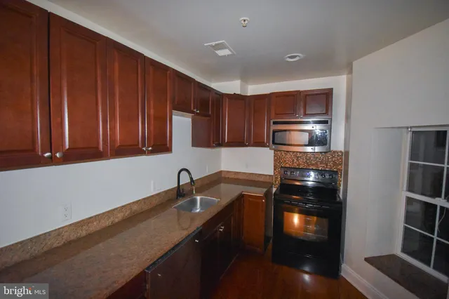 a kitchen with granite countertop stainless steel appliances and wooden cabinets