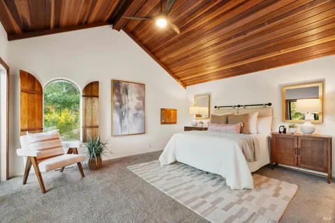 a bedroom with furniture and a large window