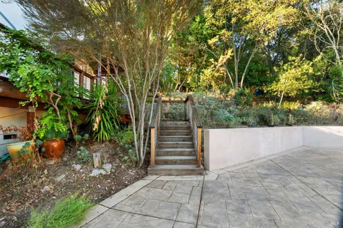 a front view of a house with wooden fence and plants