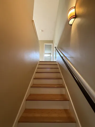 a view of an empty room with window and chandelier fan