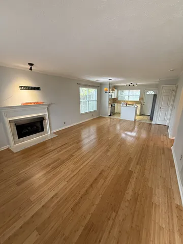 a view of empty room with wooden floor and fireplace