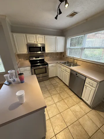 a kitchen with a sink a stove and cabinets