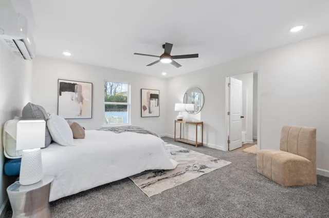 a bedroom with a bed a mirror and lamp