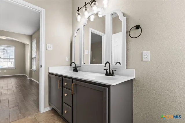 a bathroom with a double vanity sink and a mirror