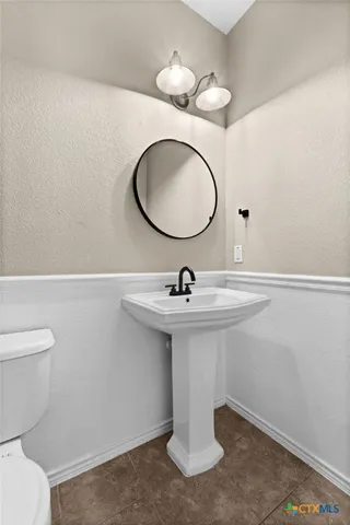 a bathroom with a sink a toilet and mirror