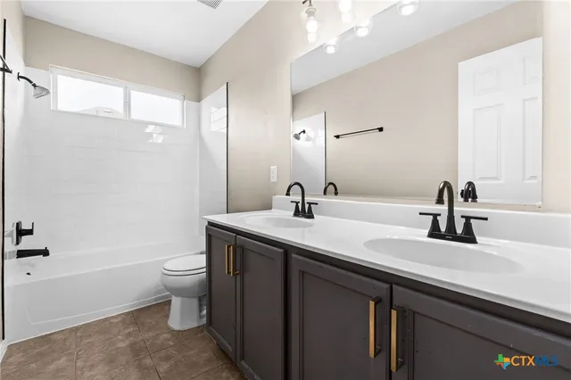 a bathroom with a double vanity sink toilet and shower