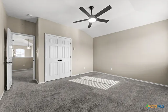 an empty room with fan and windows
